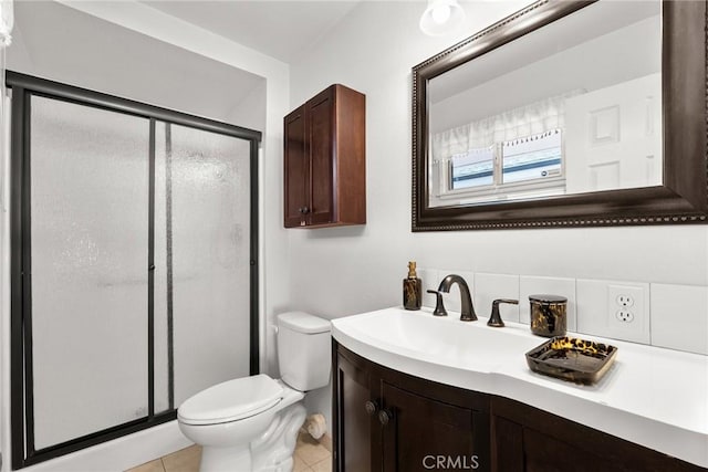 bathroom featuring tile patterned floors, vanity, toilet, and a stall shower