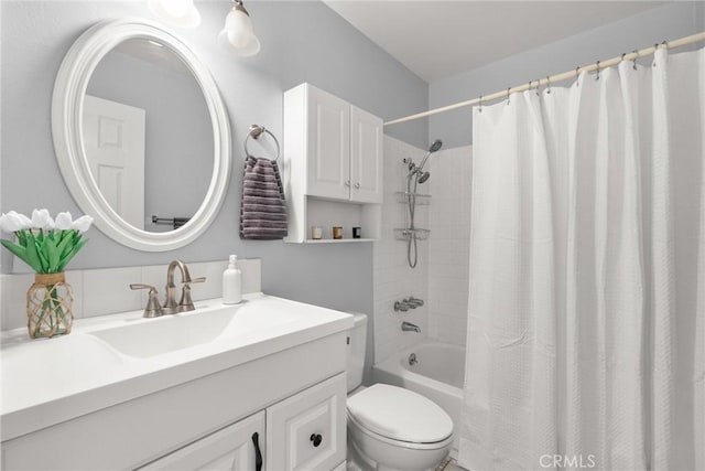 bathroom with shower / bathtub combination with curtain, vanity, and toilet
