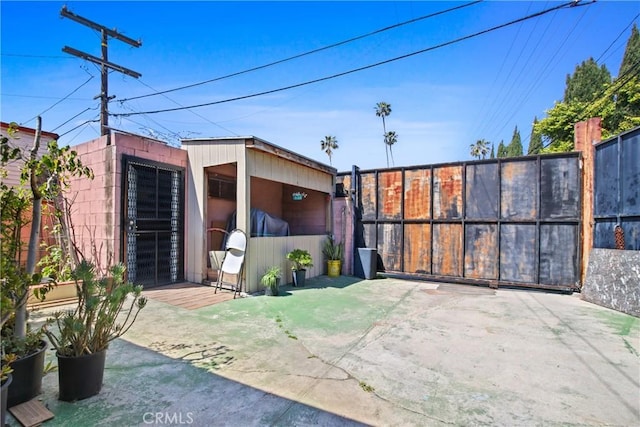 view of patio / terrace with fence and an outbuilding
