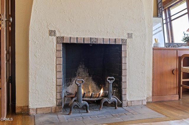 402 Lynn Dr, Ventura, CA 93003 - interior details with wood finished floors, a textured wall, and a warm lit fireplace