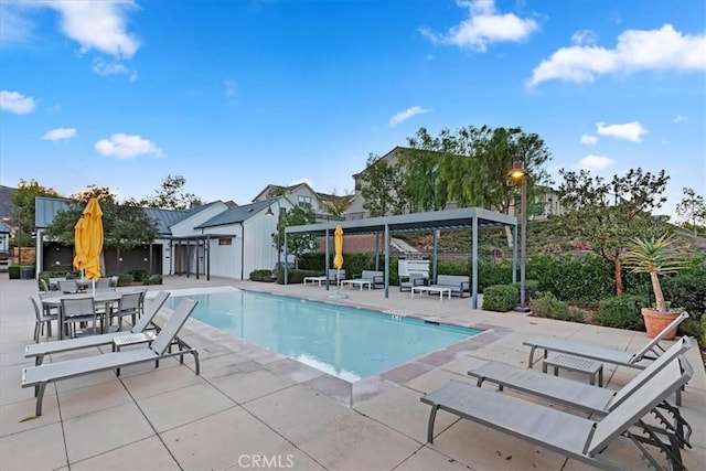 community pool with a pergola and a patio area