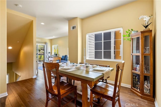 dining room featuring wood finished floors, baseboards, visible vents, and recessed lighting
