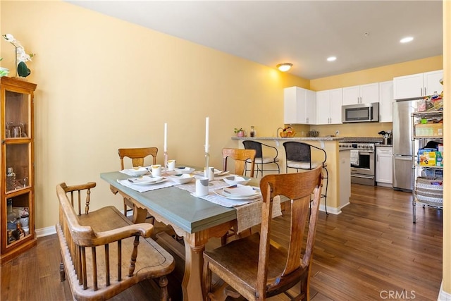 dining space featuring baseboards, recessed lighting, and dark wood finished floors
