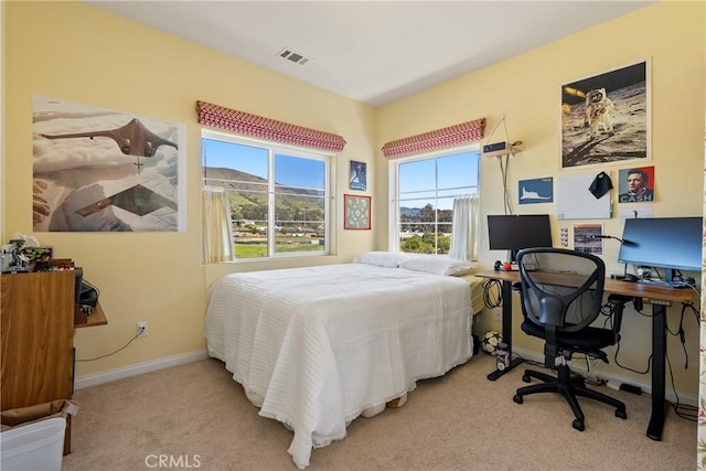 bedroom with visible vents, baseboards, and light colored carpet
