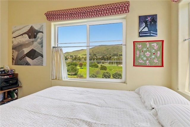 bedroom featuring multiple windows and a mountain view