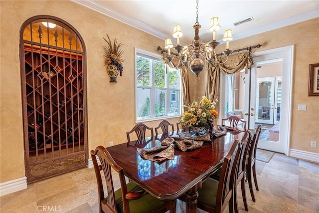 dining space with baseboards, an inviting chandelier, ornamental molding, a textured wall, and visible vents