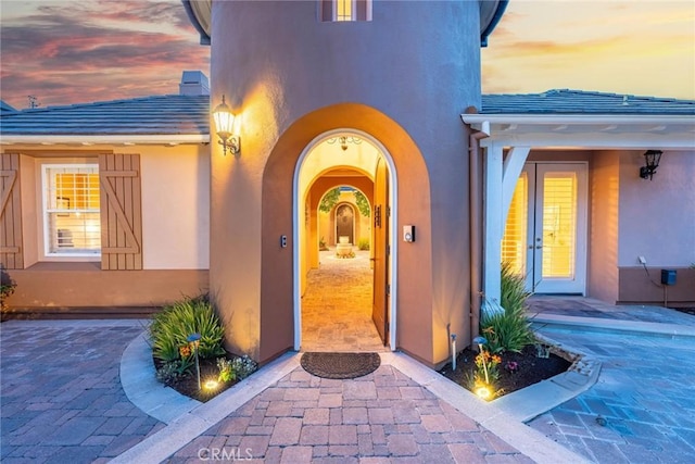 property entrance featuring a tiled roof and stucco siding
