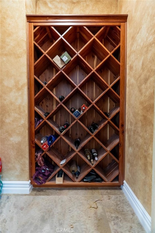 wine area with a textured wall and baseboards
