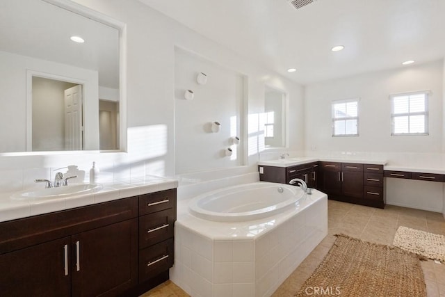 bathroom featuring recessed lighting, a bath, and a sink