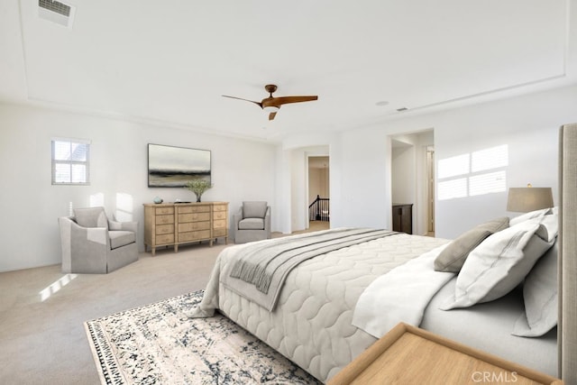 bedroom featuring light carpet, a ceiling fan, and visible vents