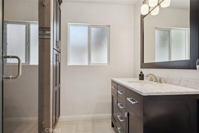 bathroom featuring vanity, baseboards, and a shower stall