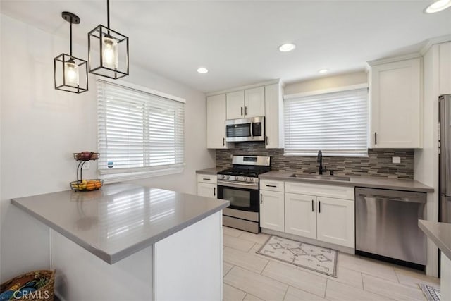 kitchen with a sink, backsplash, white cabinets, and stainless steel appliances