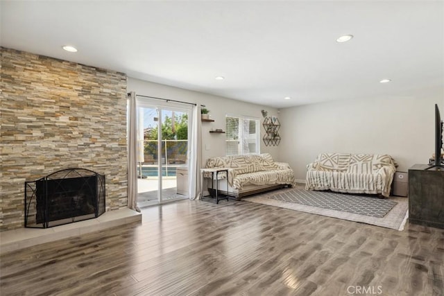 living room featuring recessed lighting, baseboards, wood finished floors, and a fireplace
