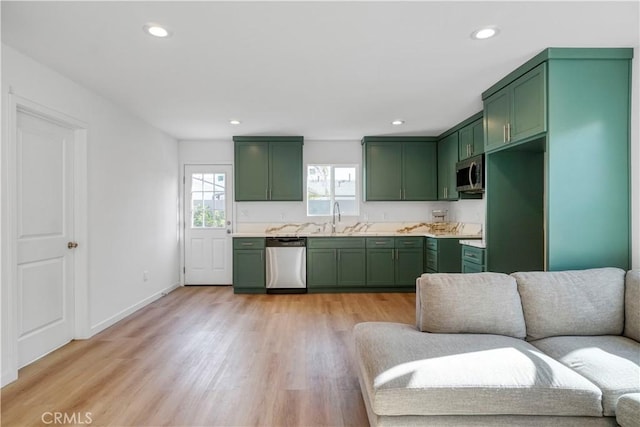 14320 Osborne St, Panorama City, CA 91402 - kitchen featuring green cabinets, stainless steel appliances, light countertops, a sink, and light wood-style flooring