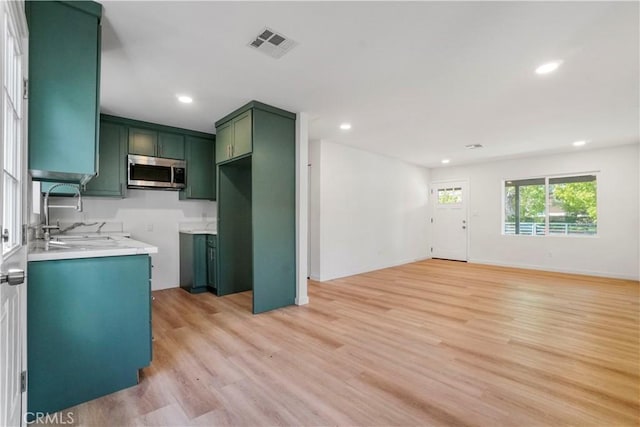 14320 Osborne St, Panorama City, CA 91402 - kitchen featuring green cabinetry, stainless steel microwave, a sink, recessed lighting, and light wood-style floors