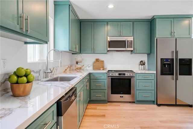 14320 Osborne St, Panorama City, CA 91402 - kitchen with stainless steel appliances, a sink, green cabinetry, light stone counters, and light wood-style flooring