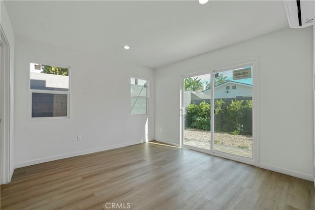 14320 Osborne St, Panorama City, CA 91402 - spare room with wood finished floors, baseboards, recessed lighting, and an AC wall unit