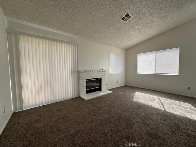 unfurnished living room featuring carpet floors, lofted ceiling, a textured ceiling, and visible vents