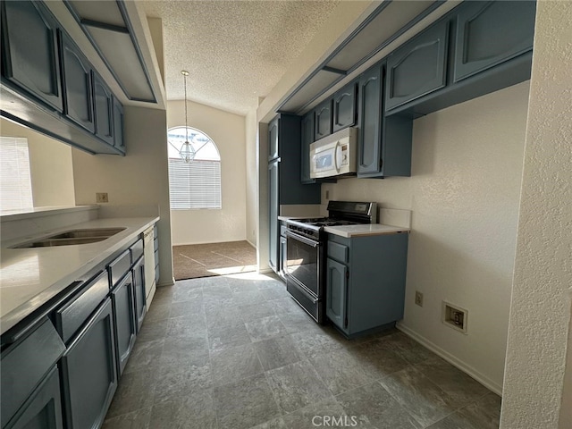 kitchen with light countertops, gas range oven, pendant lighting, white microwave, and a textured ceiling