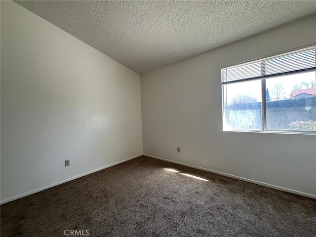 carpeted empty room with baseboards and a textured ceiling