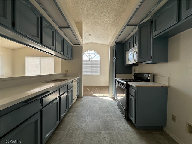 kitchen with range with gas cooktop, a textured ceiling, white microwave, and light countertops