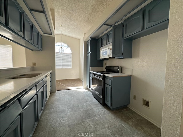 kitchen with a textured ceiling, white microwave, gas stove, light countertops, and hanging light fixtures