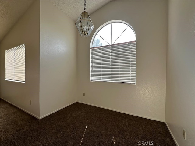 spare room featuring baseboards, vaulted ceiling, a notable chandelier, and carpet