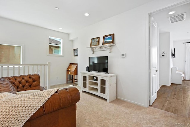 carpeted living area with recessed lighting, visible vents, and baseboards