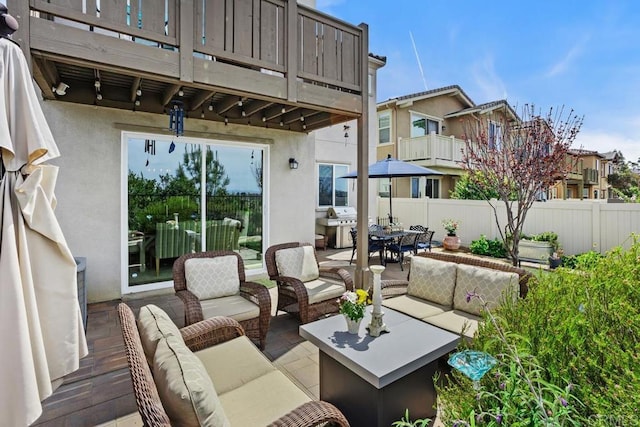 view of patio with outdoor dining space, fence, an outdoor hangout area, a balcony, and a residential view