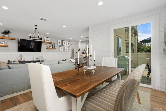 dining space featuring recessed lighting, a notable chandelier, visible vents, and wood finished floors