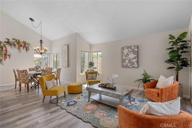78675 Bradford Cir, La Quinta, CA 92253 - living room featuring an inviting chandelier, a textured ceiling, wood finished floors, lofted ceiling, and baseboards