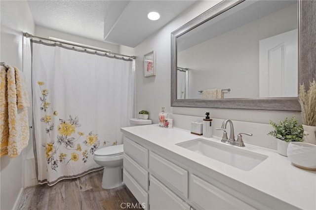 78675 Bradford Cir, La Quinta, CA 92253 - full bath with curtained shower, toilet, a textured ceiling, vanity, and wood finished floors