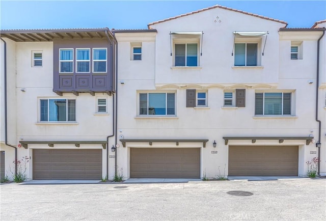 1245 Oliva Ct, Duarte, CA 91010 - rear view of house with stucco siding, a garage, and a tiled roof