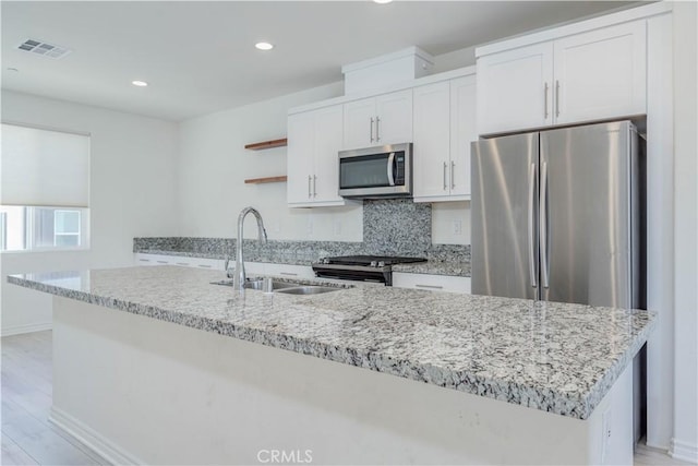 1245 Oliva Ct, Duarte, CA 91010 - kitchen with appliances with stainless steel finishes, open shelves, white cabinets, a kitchen island with sink, and light wood-type flooring