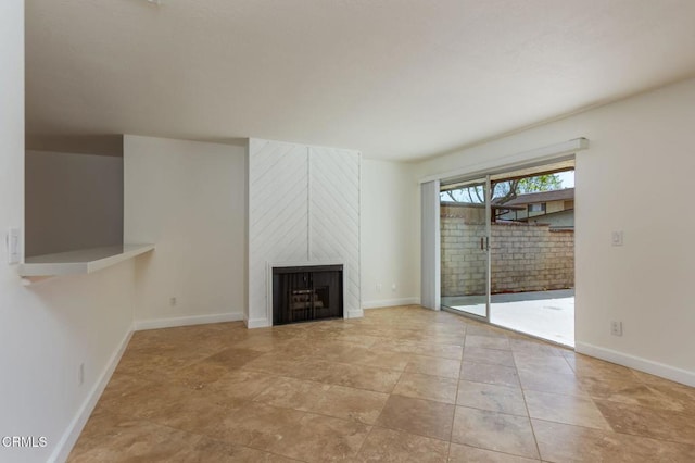 unfurnished living room with a large fireplace and baseboards