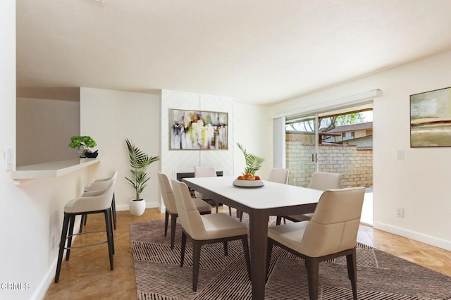 dining space featuring baseboards and light tile patterned floors