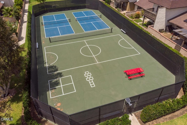 view of sport court featuring fence and a tennis court