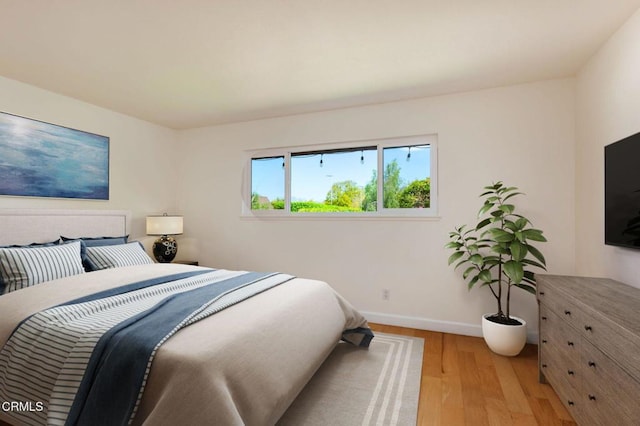 bedroom with light wood-type flooring and baseboards