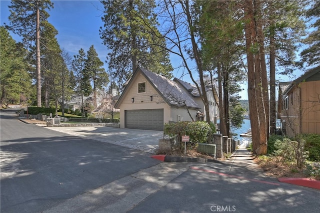 28018 Peninsula, Lake Arrowhead, CA 92352 - view of side of home featuring a garage, driveway, and stucco siding