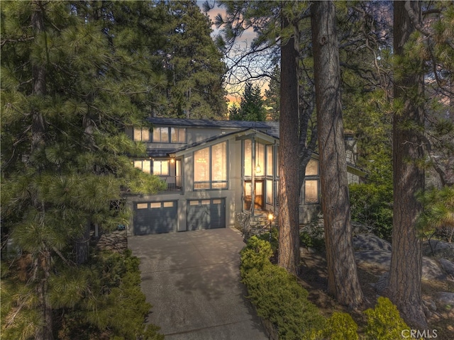 28018 Peninsula, Lake Arrowhead, CA 92352 - modern home featuring concrete driveway, an attached garage, and stucco siding