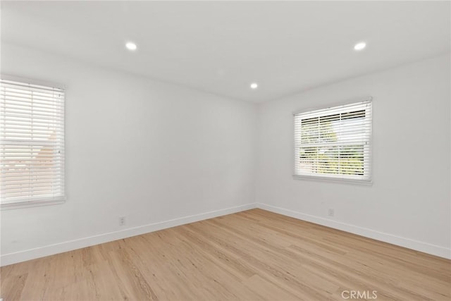 spare room with recessed lighting, baseboards, and light wood-style flooring