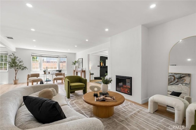 13807 Wyandotte St, Van Nuys, CA 91405 - living room featuring light wood-style floors, recessed lighting, baseboards, and a glass covered fireplace