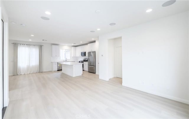 unfurnished living room featuring light wood-style flooring, recessed lighting, and baseboards