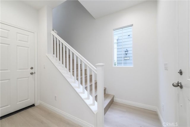 stairway featuring wood finished floors and baseboards