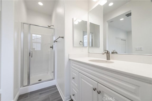 bathroom featuring a shower stall, vanity, visible vents, and recessed lighting