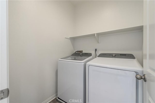 washroom with washer and clothes dryer, laundry area, and baseboards