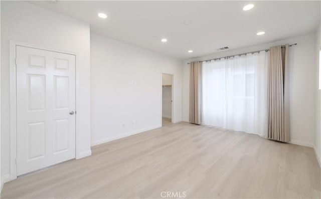 spare room with light wood finished floors, baseboards, visible vents, and recessed lighting