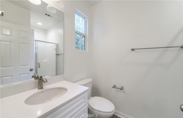 full bath featuring a shower stall, vanity, visible vents, and toilet