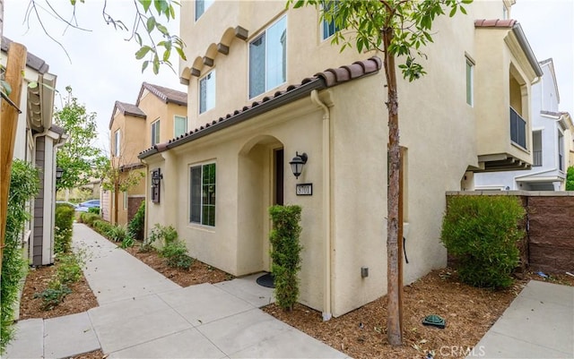 view of property exterior with stucco siding and a tiled roof