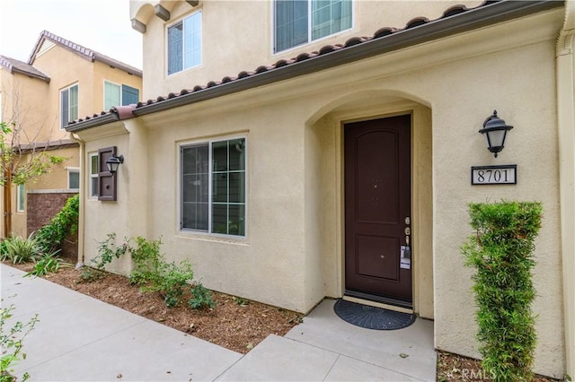 doorway to property featuring stucco siding